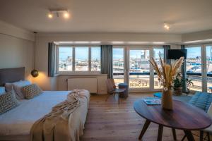 a bedroom with a bed and a table with a view at Hotel du Bassin in Ostend