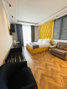 um quarto de hotel com uma cama e um sofá em Poda Boutique Hotel Ksamil em Ksamil
