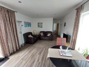a living room with a couch and a table at Dainville Retreat in Skegness