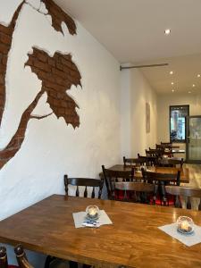 Passage 84 - Hotel & Café في هايلباد هايليغنشتات: غرفة طعام مع طاولات وكراسي خشبية
