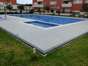 a swimming pool in a building with a tile floor at NEXTHOME Beach & Pool in Lloret de Mar