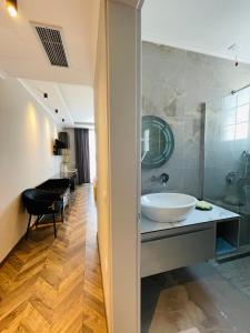 Poda Boutique Hotel Ksamil في كساميل: حمام مع حوض ومرآة