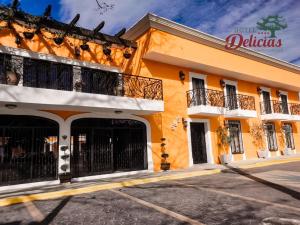 a yellow building with black gates and balconies at Hotel Delicias Tequila in Tequila