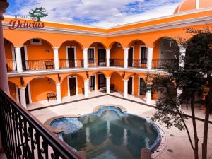 an orange building with a pool in the courtyard at Hotel Delicias Tequila in Tequila