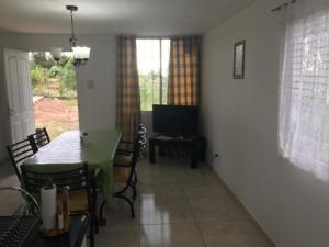 a living room with a table and a television at La Perla in Ciudad Lujan de Cuyo