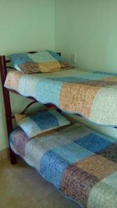 Un grupo de 4 camas en una habitación en La Perla en Luján de Cuyo