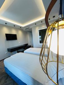 a hotel room with two beds and a tv at Poda Boutique Hotel Ksamil in Ksamil