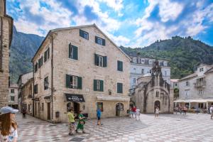 un grupo de personas de pie en una calle en una ciudad en CENTRUM HOSTEL, en Kotor