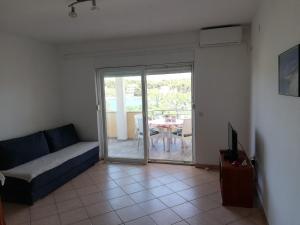 a living room with a couch and a sliding glass door at Apartments Marijan - sea view in Veli Rat