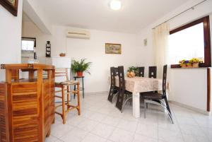 cocina y comedor con mesa y sillas en Apartments Ezgety - 330m from beach en Kaštela