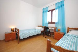1 Schlafzimmer mit 2 Betten, einem Schreibtisch und einem Fenster in der Unterkunft Apartments Ezgety - 330m from beach in Kaštela