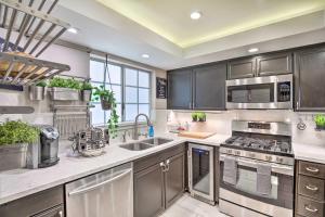 a kitchen with stainless steel appliances and a large window at Bright Burbank Condo Less Than 2 Mi to Griffith Park! in Burbank