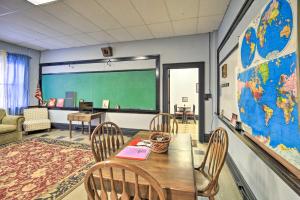 uma sala de aula com uma mesa e cadeiras e uma estufa em Unique Suite in Refurbished WV Schoolhouse! 