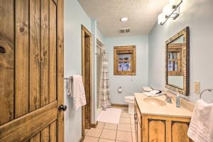 a bathroom with a sink and a toilet and a mirror at Game Room and Fire Pit Spacious Elk Park Lodge! in Elk Park +31 photos