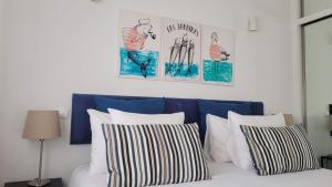ArcozeloにあるAguda Golf Vitaのベッド1台(枕4つ、壁に絵2枚付)