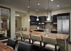 a kitchen with a large island with chairs around it at The Residences at One Village Place by Hyatt Vacation Club in Truckee