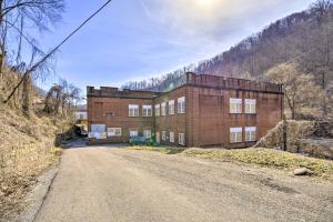 a large brick building on the side of a dirt road at Unique ATV Apartment in Remodeled Schoolhouse in Gary