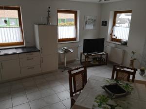 a kitchen with a table and a tv in a room at Ferienwohnung Auel in Adenau