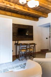 a living room with a table and chairs at Foresteria Antica Farmacia in Cedegolo