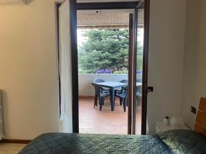a bedroom with a table and chairs and a patio at Vanti al Garda in Bardolino