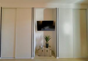 two white closets in a room with a potted plant at CHEZ FIFI - studio 28m2 - hyper centre - wifi in Cassis