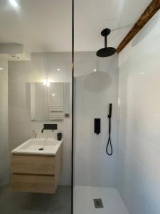 a white bathroom with a sink and a shower at CHEZ FIFI - studio 28m2 - hyper centre - wifi in Cassis +12 photos