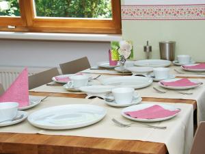 einen Tisch mit weißen Platten und rosa Servietten darauf in der Unterkunft Holiday Home Runnimoos-1 by Interhome in Innerlaterns