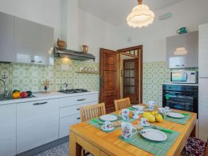 una cucina con tavolo in legno, piatti e frutta di Holiday Home Mauro by Interhome a Tonfano