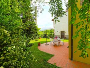 um pátio com uma mesa e cadeiras num quintal em Holiday Home Il Masso-4 by Interhome em La Collina