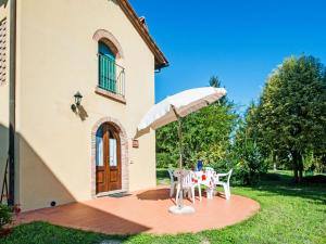 uma mesa com um guarda-chuva em frente a uma casa em Holiday Home Il Masso-4 by Interhome em La Collina