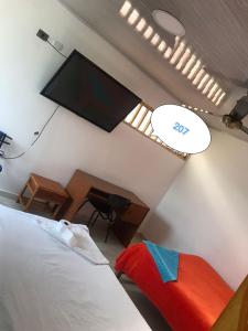 a bedroom with a flat screen tv on the wall at Brisas del Magdalena in La Dorada