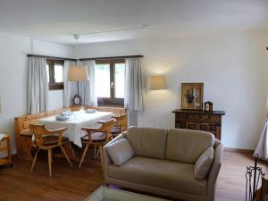 un soggiorno con divano e tavolo di Apartment Chesa Mulin by Interhome a Celerina