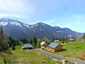 a house in a field with mountains in the background at Holiday Home Runnimoos-3 by Interhome in Laterns