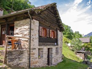 una pequeña casa de piedra en una colina con césped en Holiday Home Rustico Fey by Interhome, en Malvaglia