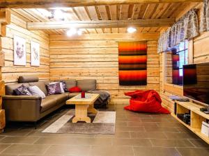 ein Wohnzimmer mit Sofa und Tisch in der Unterkunft Holiday Home Kiviniemi by Interhome in Siikakämä