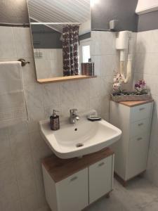 a bathroom with a white sink and a mirror at Nikolas House Upper Agni Bay in Agní