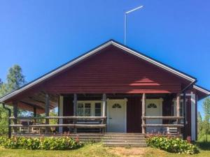 a small red house with a porch and stairs at Holiday Home Riihiranta by Interhome in Petäjävesi