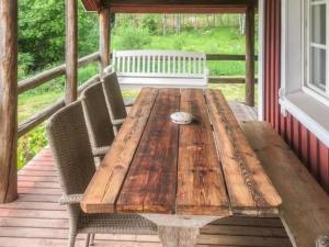 a wooden table and chairs on a porch at Holiday Home Riihiranta by Interhome in Petäjävesi