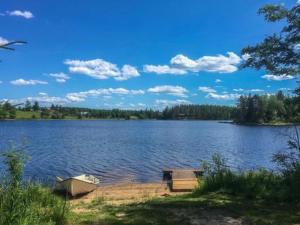 a lake with a boat and a bench on the shore at Holiday Home Riihiranta by Interhome in Petäjävesi