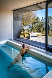 un hombre nadando en una piscina en una casa en Casa das Penhas Douradas - Burel Mountain Hotels, en Manteigas