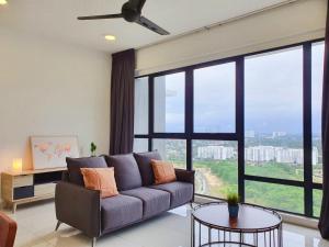 a living room with a couch and a large window at Southkey Mosaic Mid Valley Johor Bahru in Johor Bahru