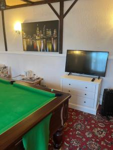 a room with a pool table and a flat screen tv at Jasmine House in Newquay