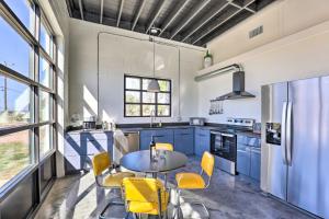 a kitchen with blue cabinets and a table and yellow chairs at Unique Texas Home in Converted Gas Station! in Schulenburg