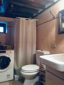 La salle de bains est pourvue de toilettes, d'un lavabo et d'un lave-linge. dans l'établissement I Poderi - Lovely Country House in Maremma, à Caldana