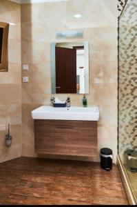 a bathroom with a sink and a mirror at ROYAL BASIN RESORT in Kumasi