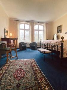 DaschowにあるLandhotel Schloss Daschowのベッドルーム1室(ベッド1台付)、リビングルームが備わります。