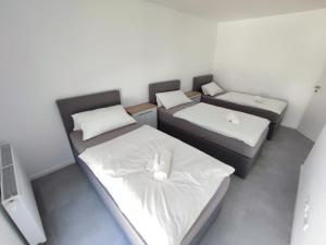 Kleines Zimmer mit 2 Betten und weißer Bettwäsche in der Unterkunft Ferienwohnungen am Stadtgarten Pforzheim in Pforzheim