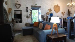 a living room with a blue couch and a lamp at Casa da Pedreira in Mosteiros