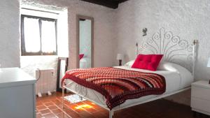 a bedroom with a white bed with red pillows at Casa da Pedreira in Mosteiros