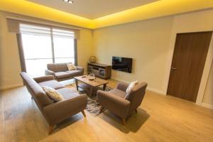 a living room with two couches and a tv at Accra Luxury Apartments @ Pearl in Accra